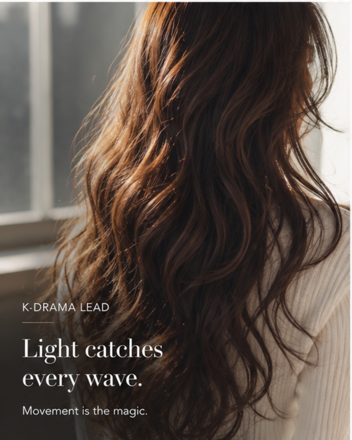 Back view of long warm-toned waves catching window light